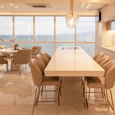 Cozinha e sala integradas com vista para o mar e janelas amplas