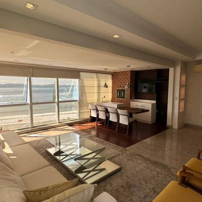 Sala de estar com vista para o mar e janelas grandes