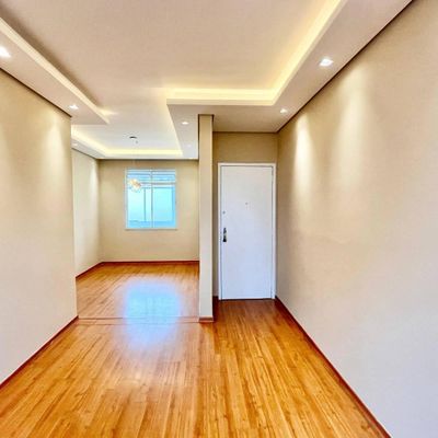 Sala com acabamento em drywall, iluminação embutida, piso de madeira