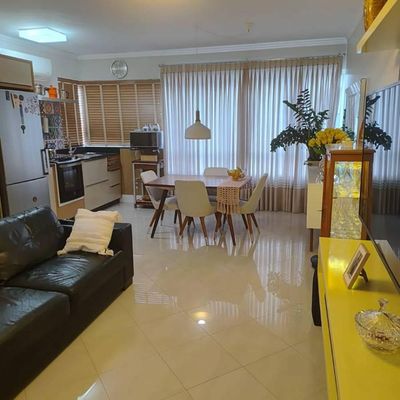 Sala conjugada com cozinha, móveis modernos e iluminação de LED.