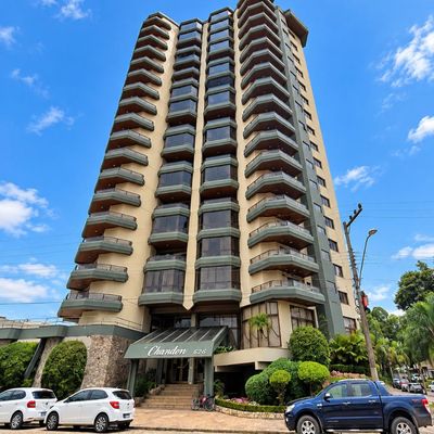 Prédio residencial de concreto com janelas de vidro e varandas em verticais.